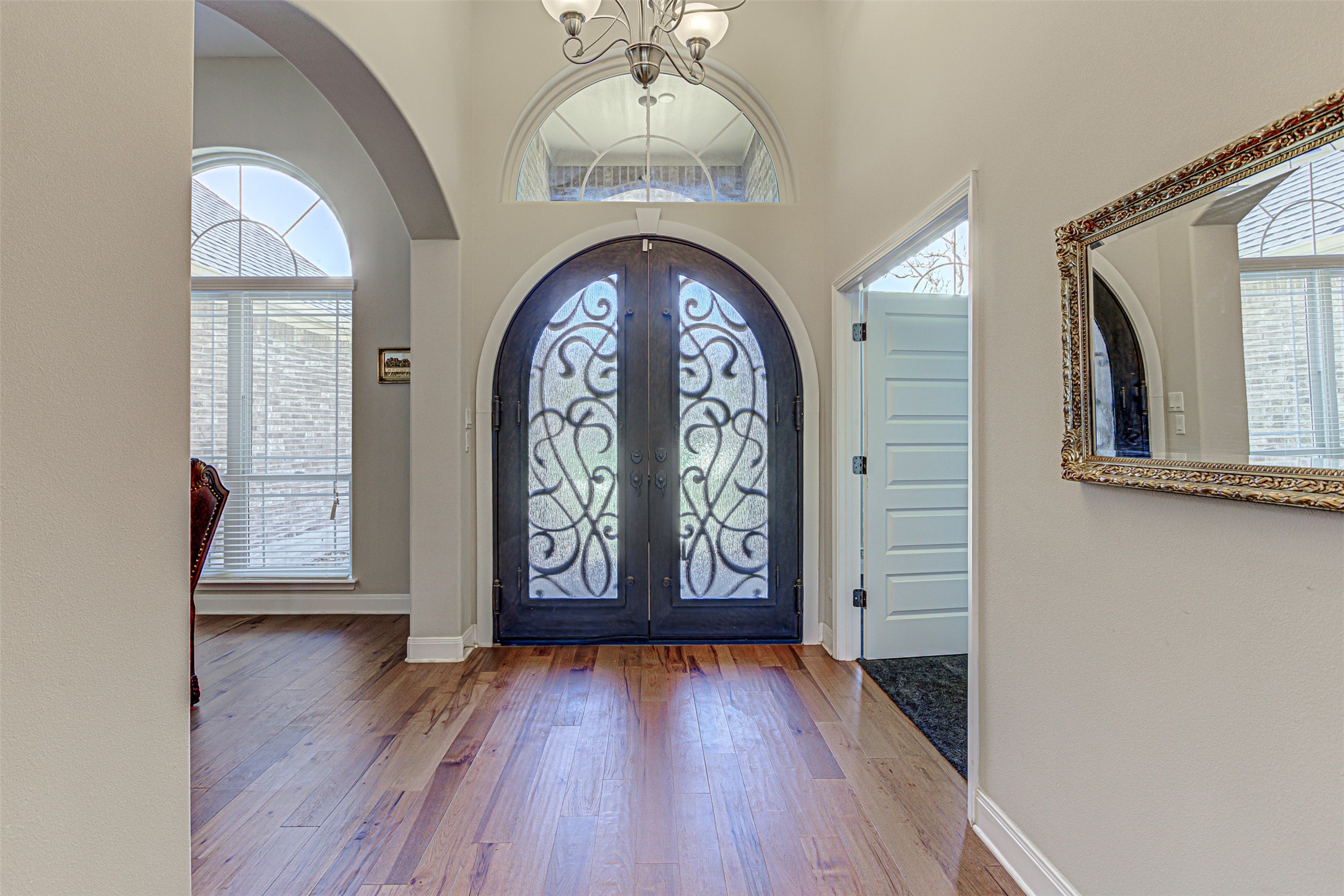 105 Arbors Circle Elgin, TX 78621 - Photo 3 of 40 Entryway with arched walkways, a chandelier, french doors, wood finished floors, and healthy amount of natural light