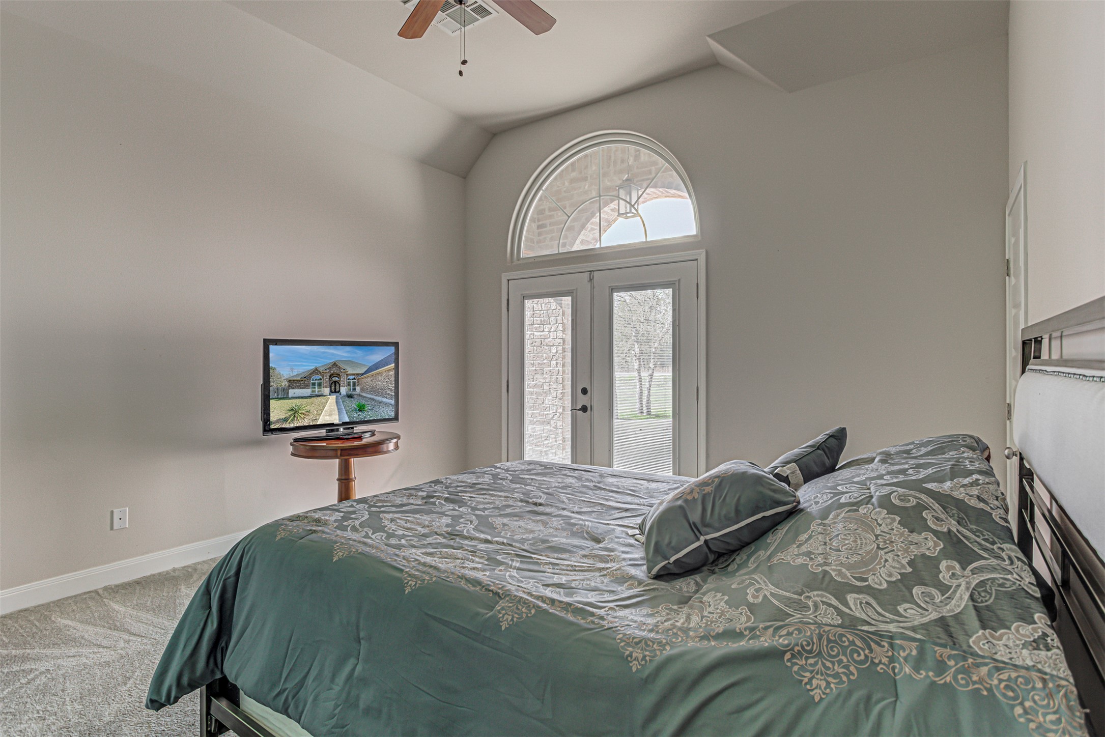 105 Arbors Circle Elgin, TX 78621 - Photo 35 of 40 Bedroom featuring access to exterior, vaulted ceiling, light carpet, french doors, and a ceiling fan