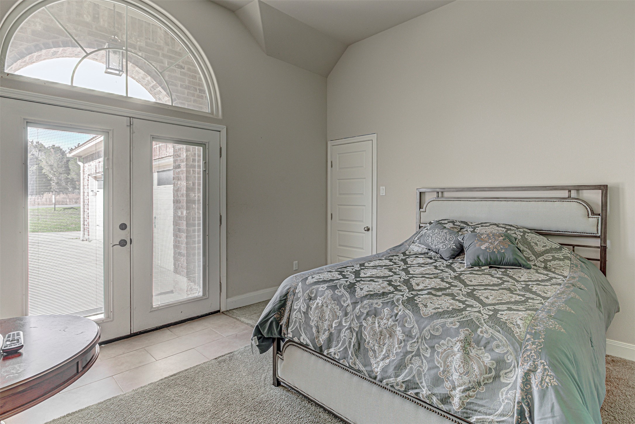 105 Arbors Circle Elgin, TX 78621 - Photo 36 of 40 Bedroom featuring french doors, lofted ceiling, access to exterior, light colored carpet, and light tile patterned flooring