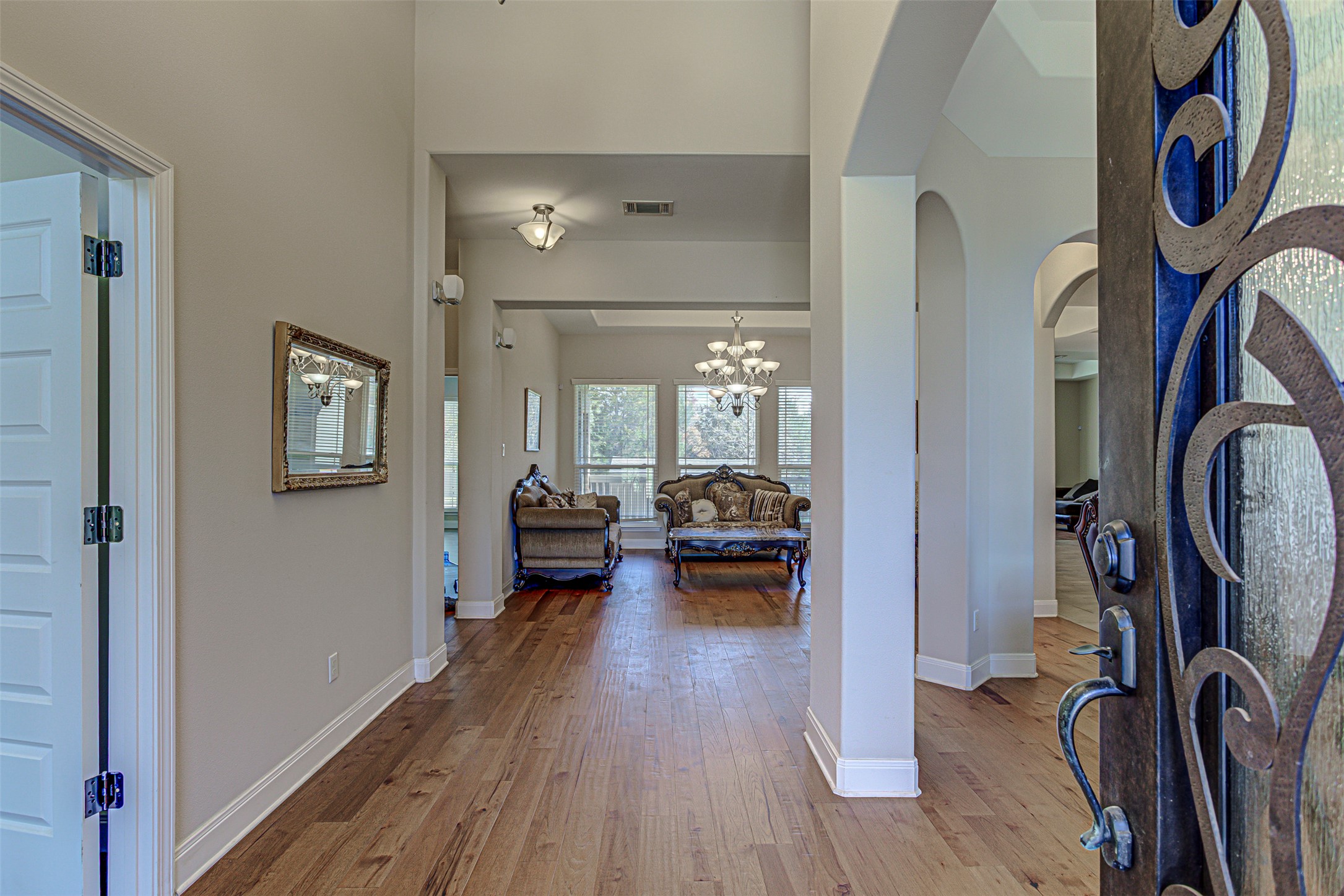 105 Arbors Circle Elgin, TX 78621 - Photo 4 of 40 Entryway with light wood-type flooring, arched walkways, and suspended lighting