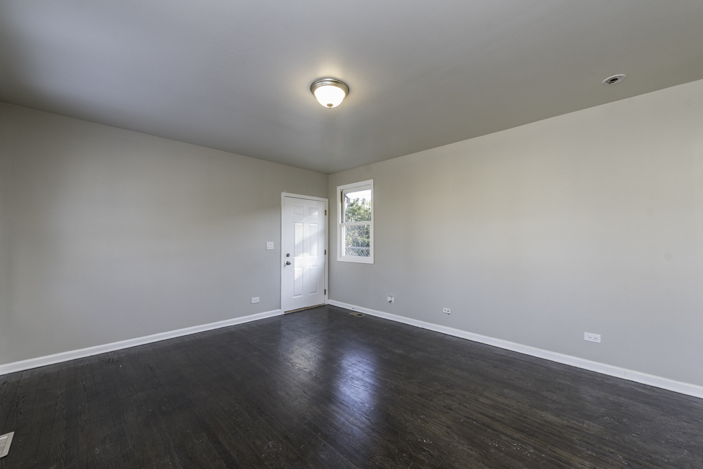 821 12th Street North Chicago, IL 60064 - Photo 15 of 25 a view of an empty room with wooden floor and a window