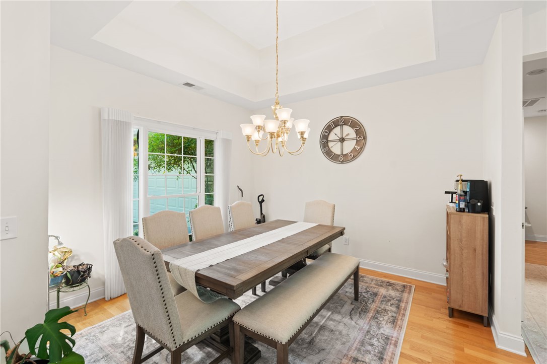 108 Winterbrook Circle Seneca, SC 29678 - Photo 9 of 40 A refined dining space features a warm hardwood floor and a stately tray ceiling, ideal for formal entertaining.