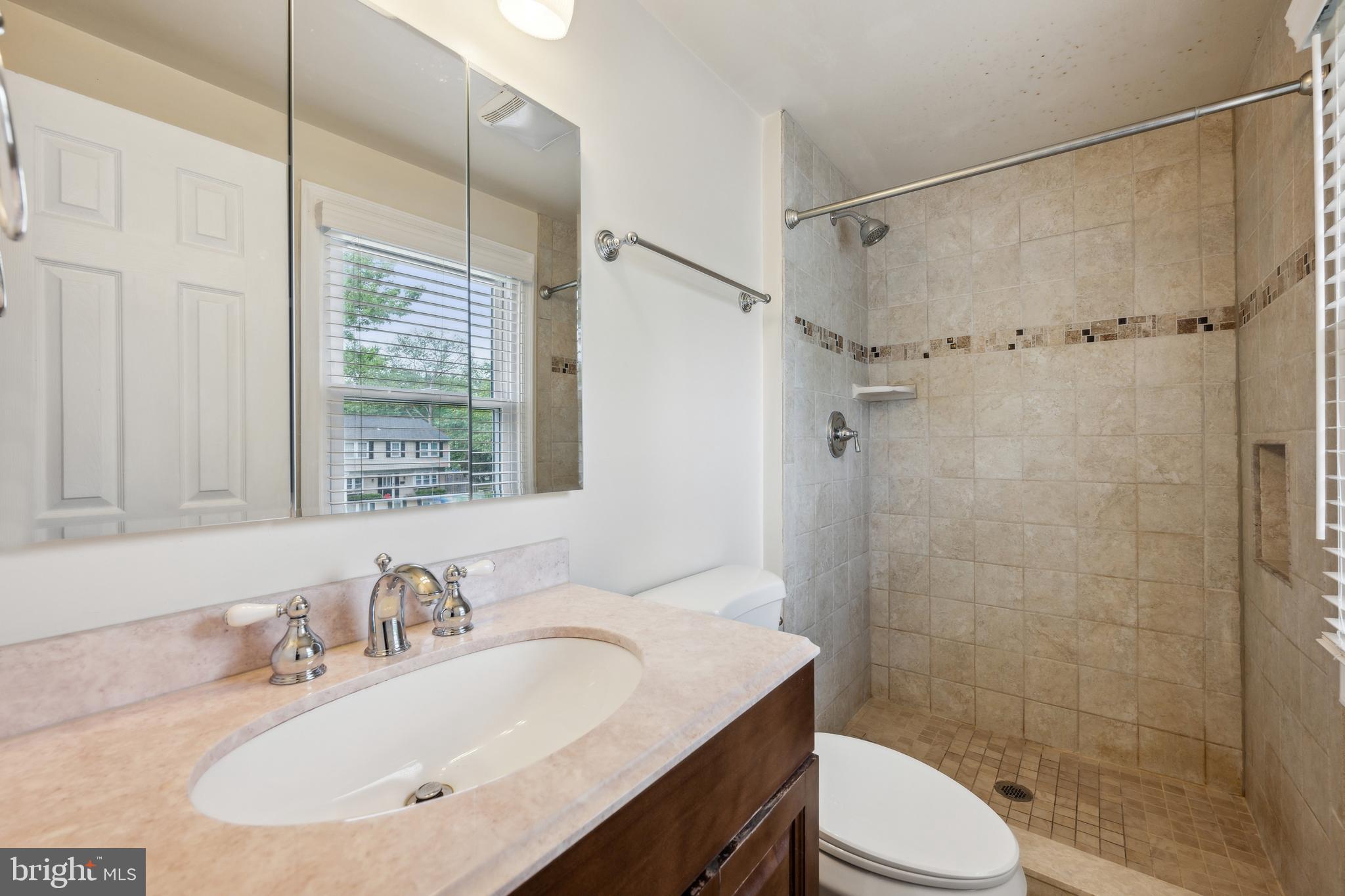 12430 Shadow Lane Bowie, MD 20715 - Photo 13 of 24 a bathroom with a sink toilet a mirror and shower