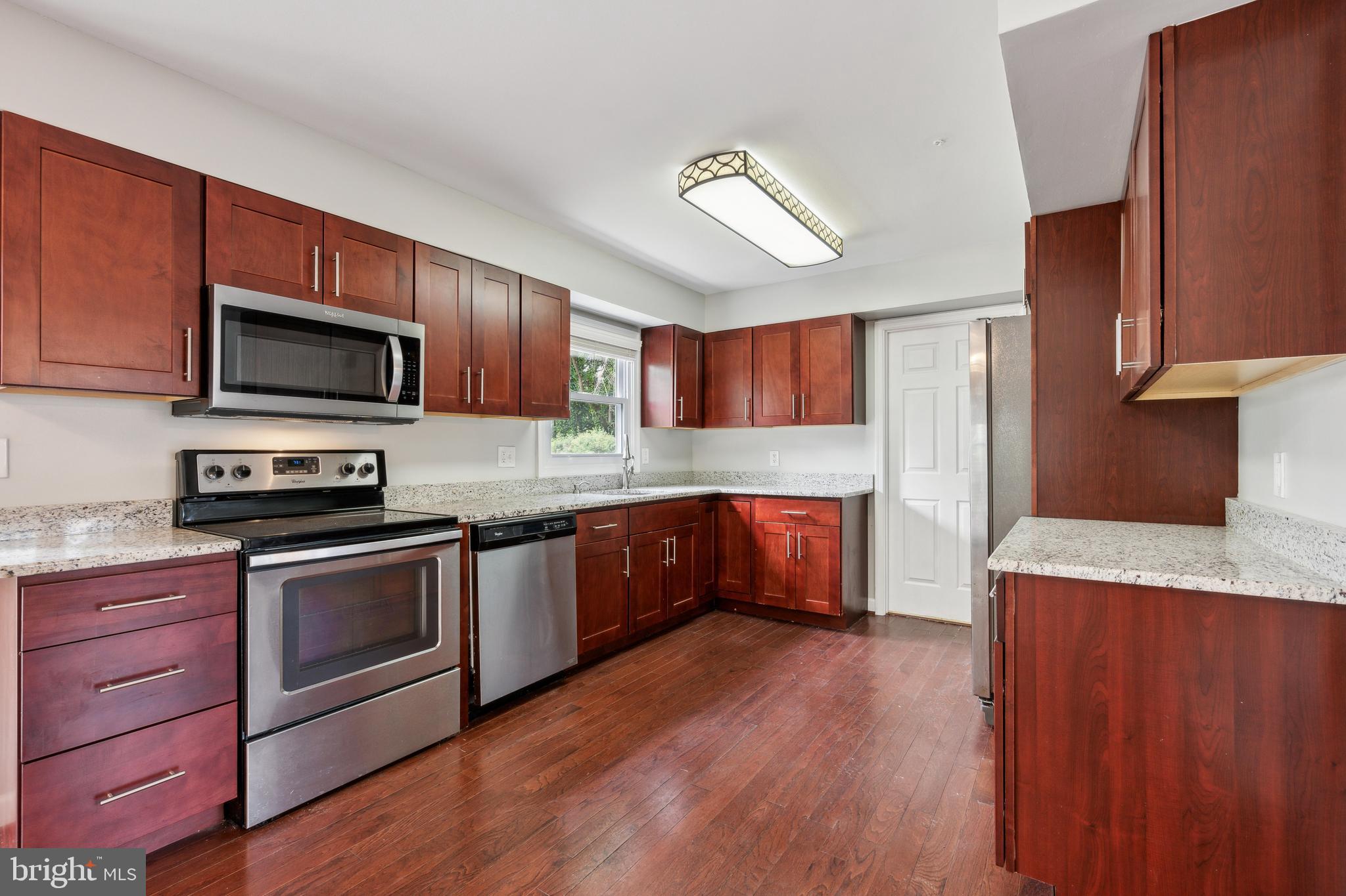 12430 Shadow Lane Bowie, MD 20715 - Photo 5 of 24 a kitchen with stainless steel appliances granite countertop wooden cabinets a stove top oven a sink and dishwasher