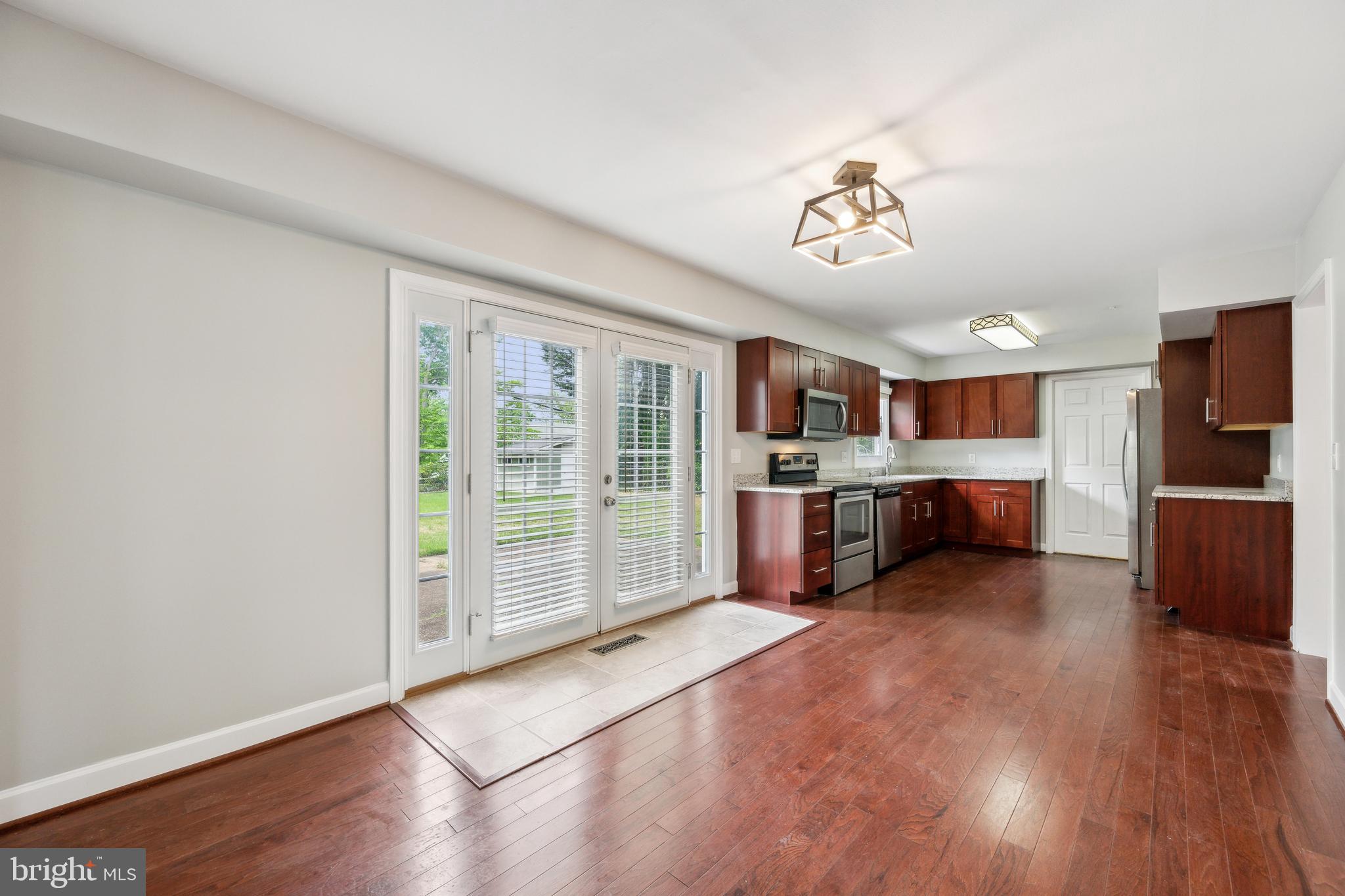 12430 Shadow Lane Bowie, MD 20715 - Photo 7 of 24 a view of a kitchen with furniture a ceiling fan and wooden floor