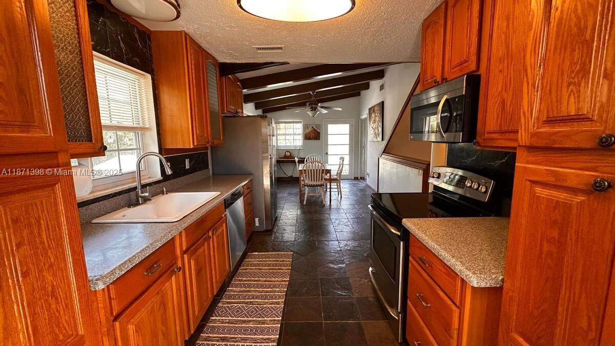 22488 Southwest Nautilus Boulevard, Unit 2 Dunnellon, FL 34431 - Photo 1 of 7 a kitchen with wooden cabinets and a sink