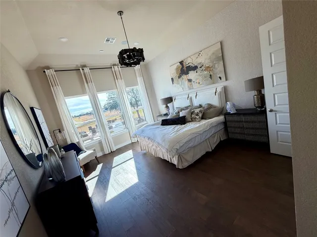 a bed room with a bed window and a flat tv screen