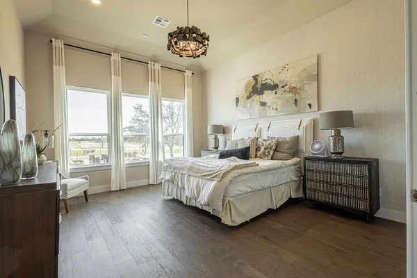 a bedroom with a large bed and a wooden floor