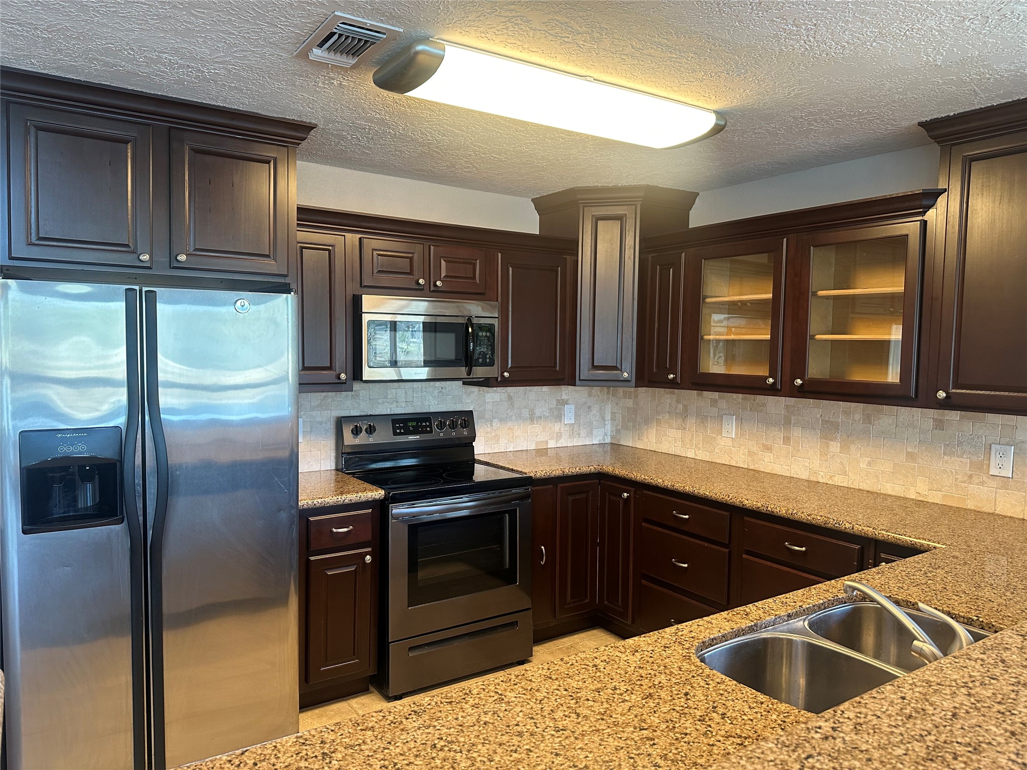 20527 Rio Villa Drive Houston, TX 77049 - Photo 11 of 18 a kitchen with stainless steel appliances kitchen island granite countertop a sink stove and refrigerator