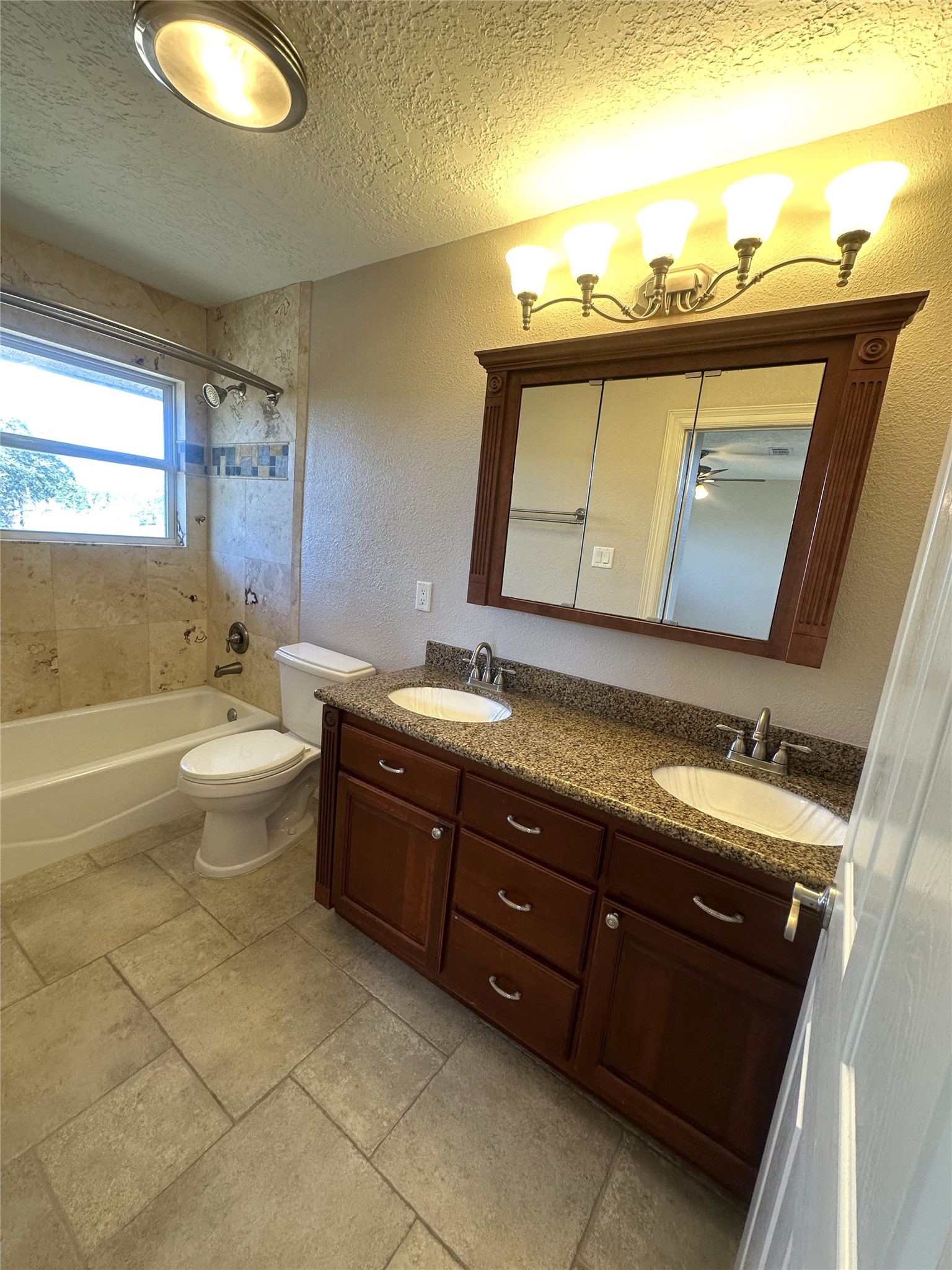 20527 Rio Villa Drive Houston, TX 77049 - Photo 17 of 18 a bathroom with a granite countertop sink a toilet a mirror and bathtub