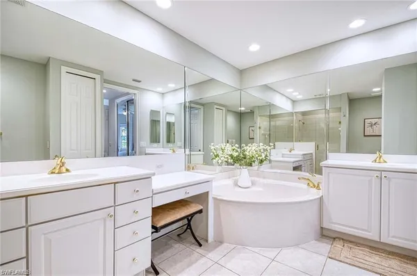 a bathroom with a tub sink and mirror
