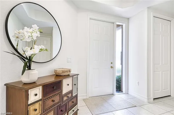an entryway with a mirror and a table in it