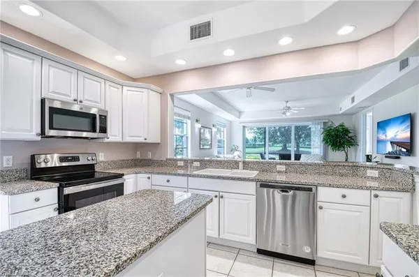 a kitchen with stainless steel appliances granite countertop a sink stove and cabinets