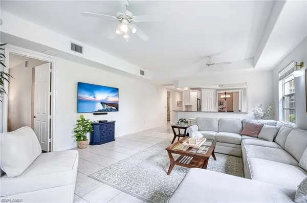 a living room with furniture a ceiling fan and a window