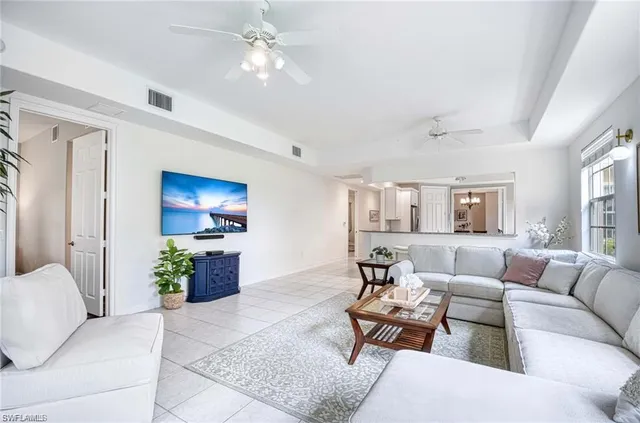 a living room with furniture a ceiling fan and a window