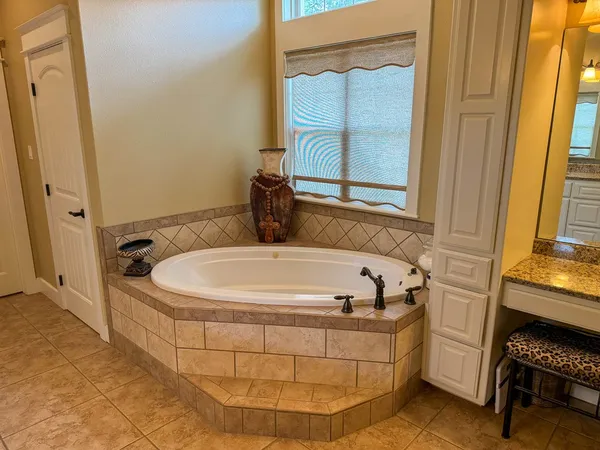 a white bath tub sitting in a bathroom next to a window
