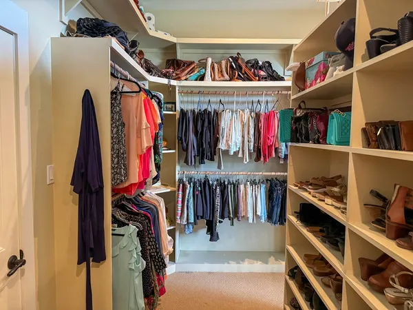a view of walk in closet with clothes and shoes