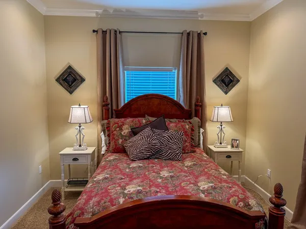 a bedroom with a bed next to a window and a lamp