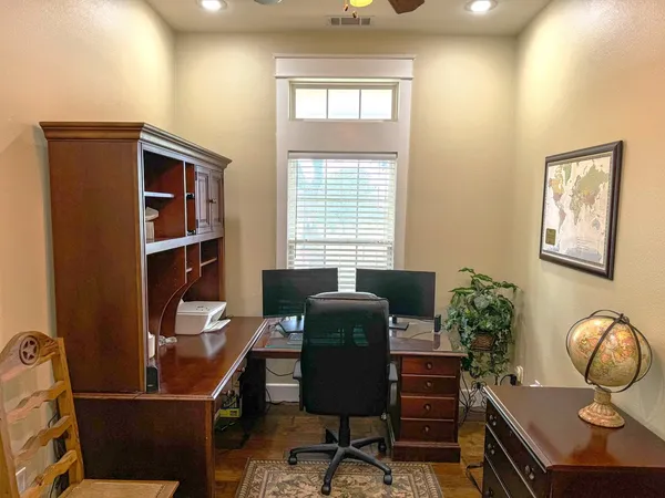 a view of a workspace with furniture and a window