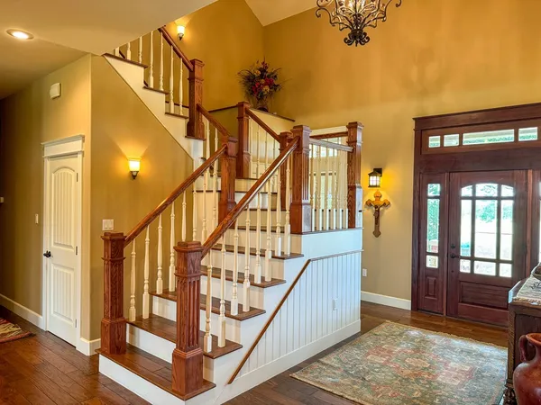 a view of staircase with lots of frames on wall and a window