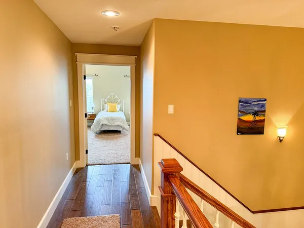 a view of a hallway with wooden floor and stairs