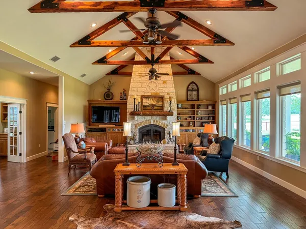 a living room with furniture a fireplace and a floor to ceiling window