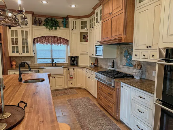 a kitchen with stainless steel appliances granite countertop a stove sink and cabinets