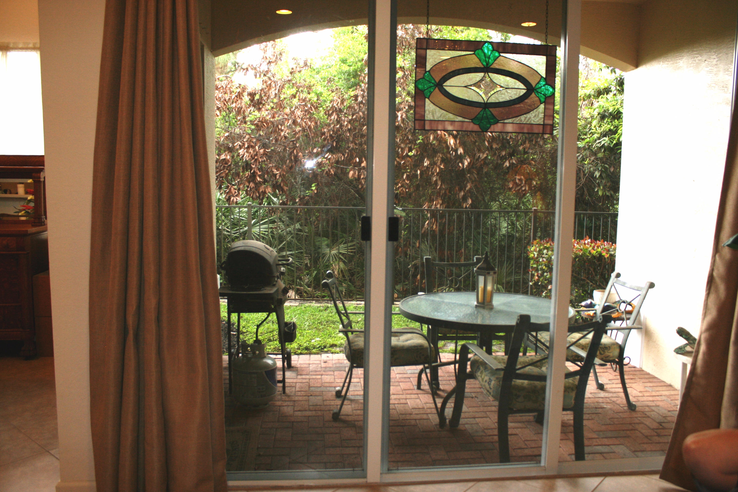 326 Southwest Walking Path Stuart, FL 34997 - Photo 8 of 49 a view of a patio with table and chairs and floor to ceiling window