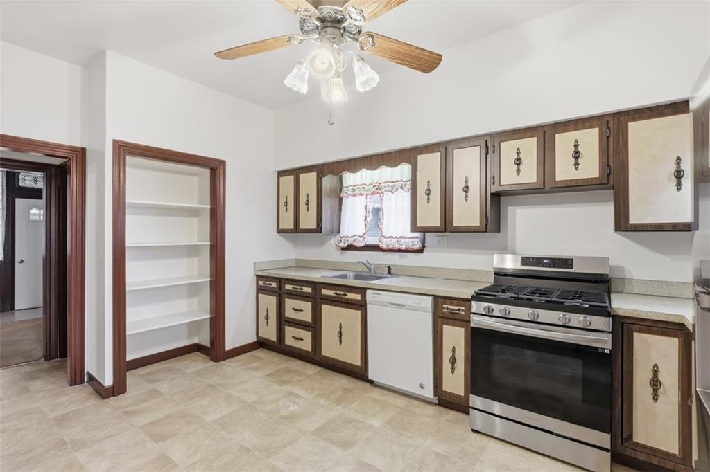 218 10th Street Aspinwall, PA 15215 - Photo 21 of 49 a kitchen with stainless steel appliances granite countertop a stove and a sink