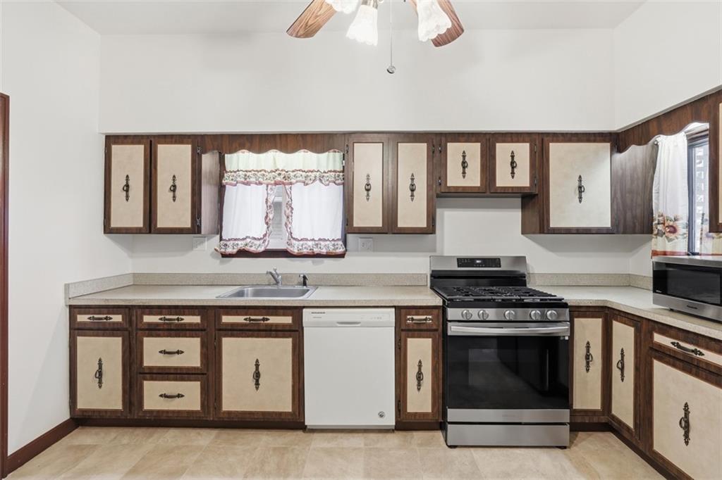 218 10th Street Aspinwall, PA 15215 - Photo 22 of 49 a kitchen with stainless steel appliances a stove and white cabinets