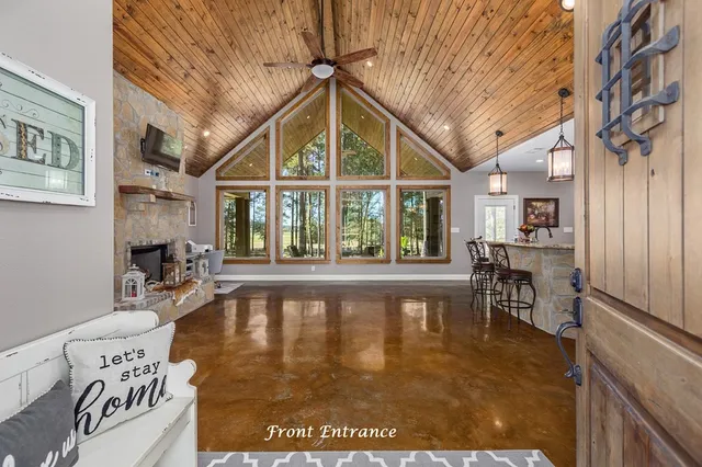 a view of an empty room with wooden floor and a fireplace