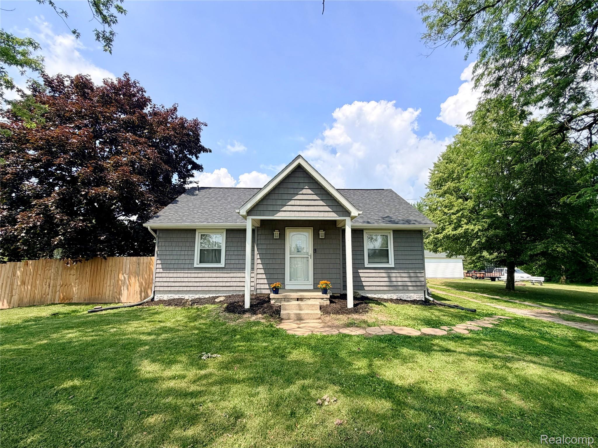 3840 East Dunbar Road Monroe, MI 48161 - Photo 1 of 38 Charming single-story home featuring gray shingle siding, a white front door, and a covered entryway