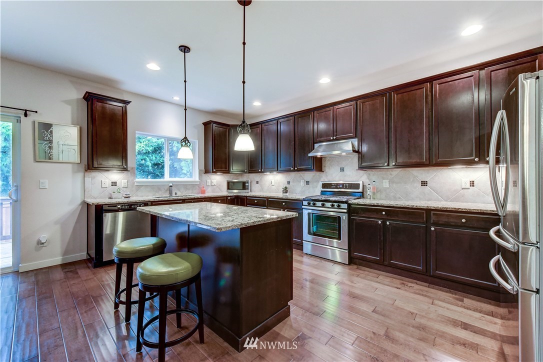 22330 35th Drive Southeast Bothell, WA 98021 - Photo 5 of 25 a kitchen with stainless steel appliances granite countertop wooden cabinets a stove top oven a sink and dishwasher