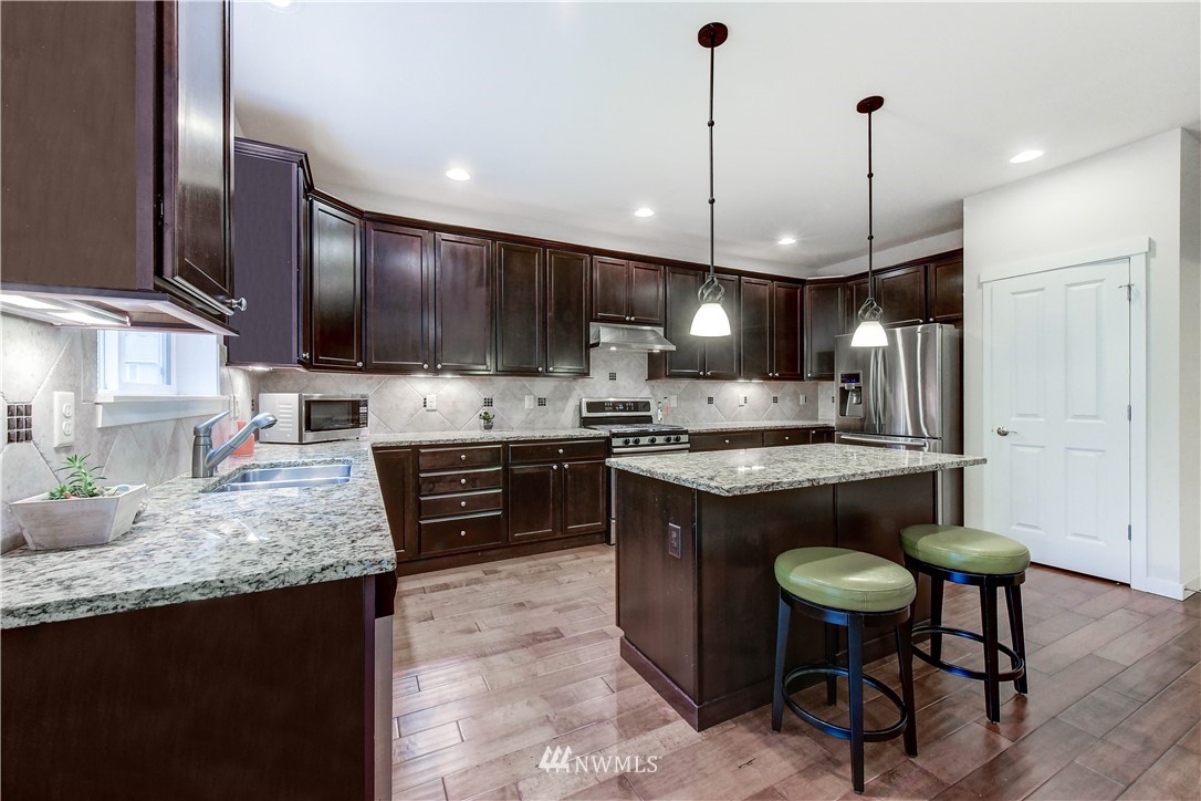 22330 35th Drive Southeast Bothell, WA 98021 - Photo 6 of 25 a kitchen with stainless steel appliances granite countertop a stove refrigerator sink and microwave