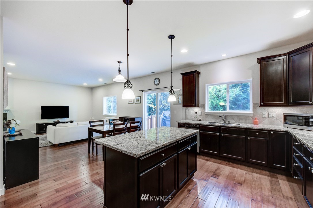 22330 35th Drive Southeast Bothell, WA 98021 - Photo 7 of 25 a kitchen with granite countertop stove sink and wooden floor