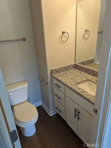 a bathroom with a granite countertop toilet sink and mirror