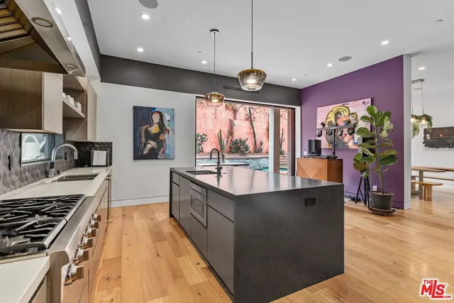 a large kitchen with stainless steel appliances granite countertop a stove and a large window