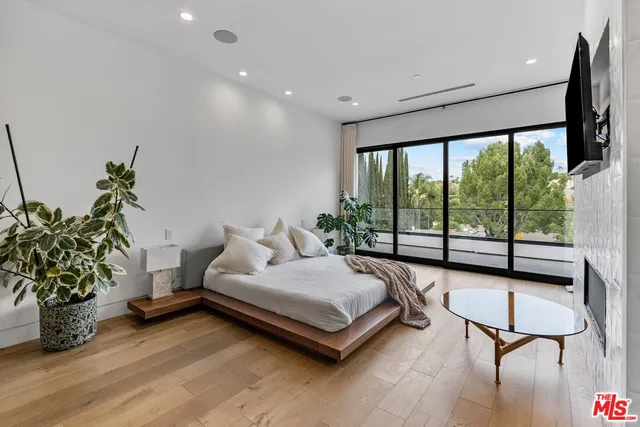 a spacious bedroom with a bed and a large window