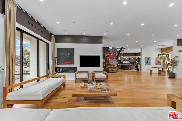 a living room with fireplace furniture and a large window