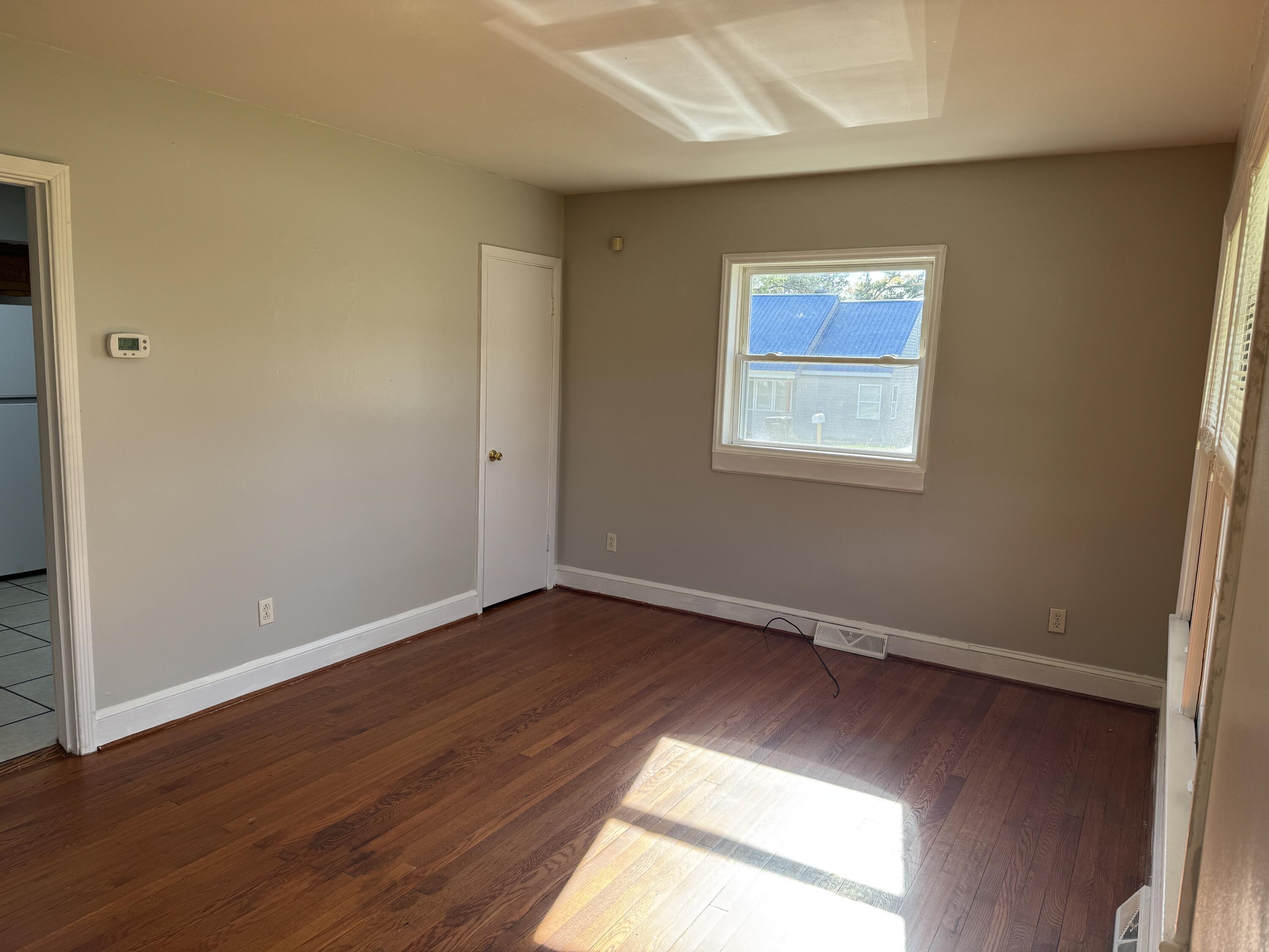 357 Terry Avenue Danville, VA 24540 - Photo 4 of 8 an empty room with wooden floor and windows