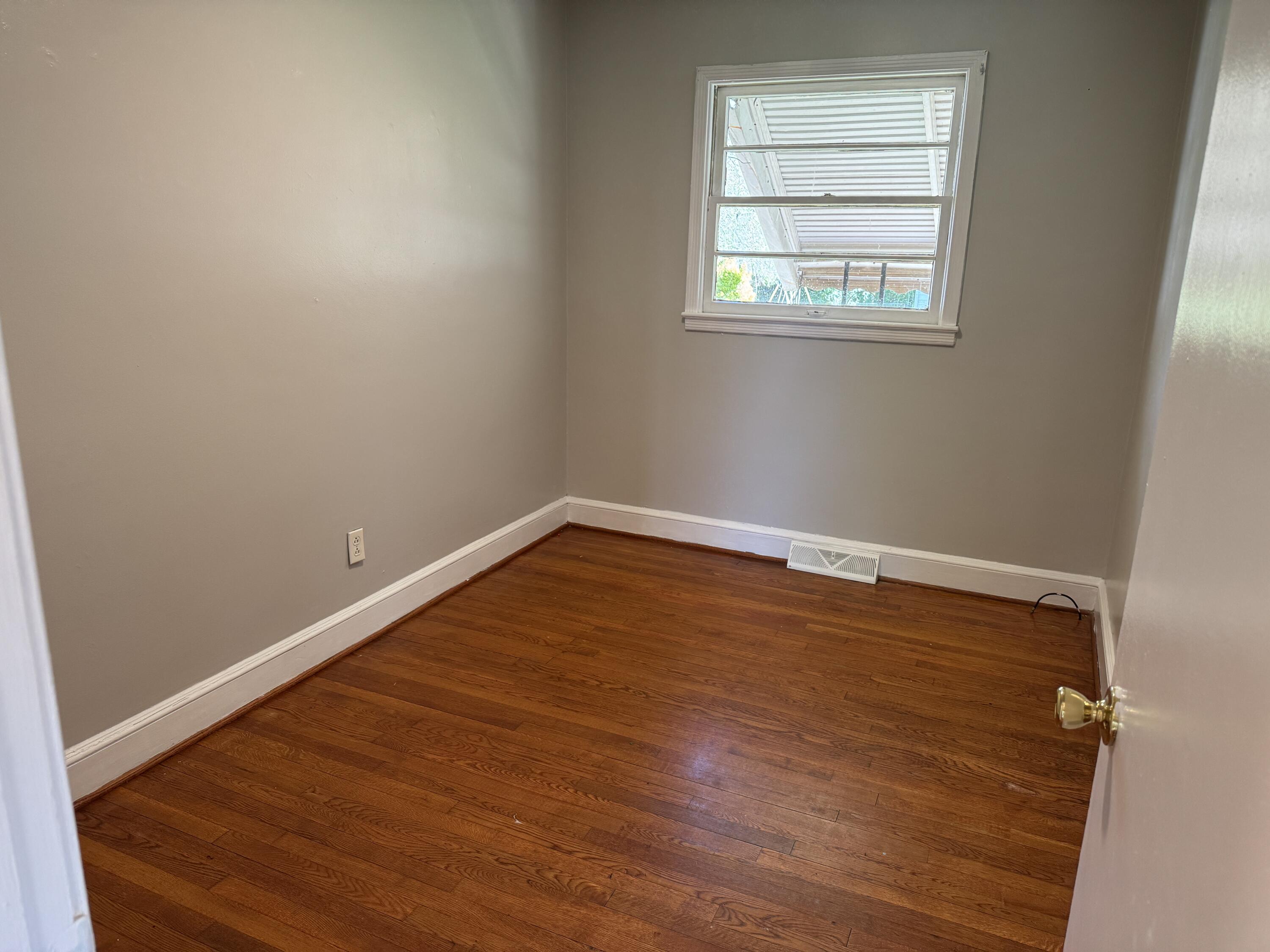 357 Terry Avenue Danville, VA 24540 - Photo 5 of 8 an empty room with wooden floor and windows