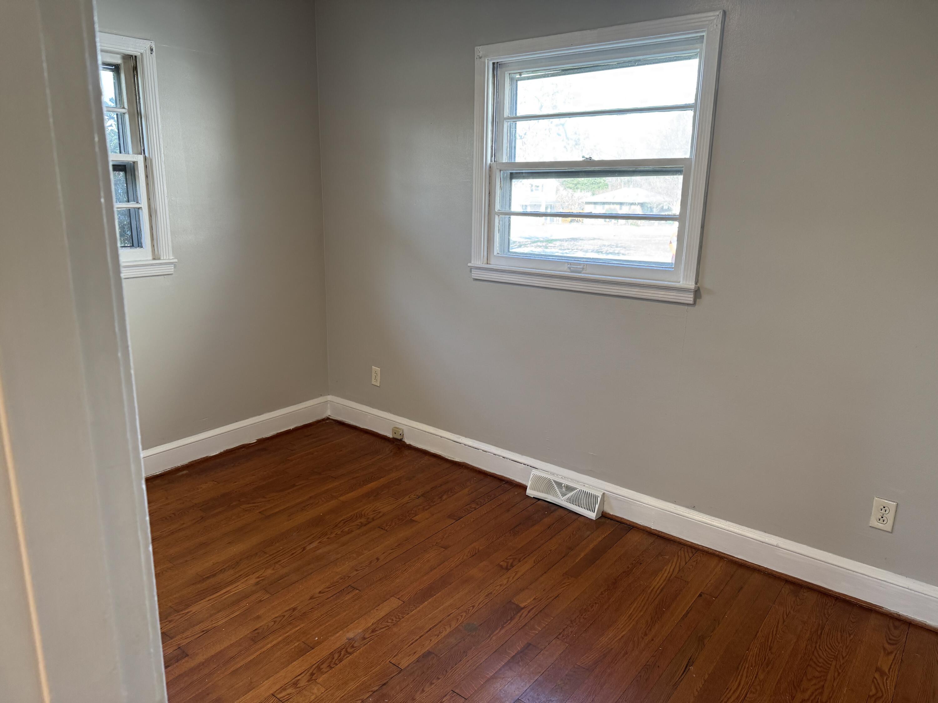 357 Terry Avenue Danville, VA 24540 - Photo 6 of 8 an empty room with wooden floor and windows