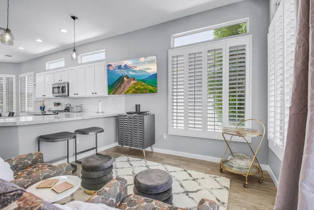 a living room with lots of white furniture and a chandelier