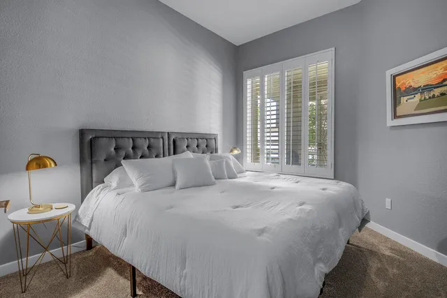 a bedroom with a bed and a painting on the wall