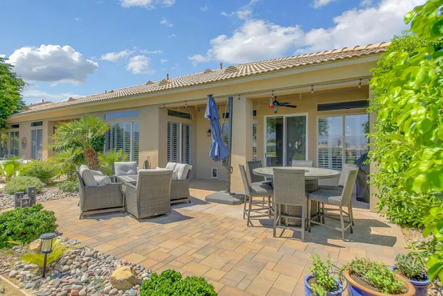 a view of a patio with couches table and chairs and potted plants