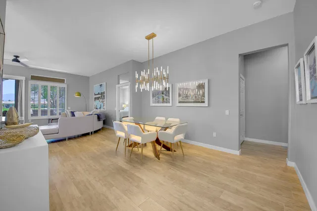 a dining room with wooden floor and large windows