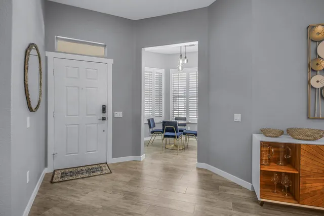 a dining room with furniture a chandelier and wooden floor
