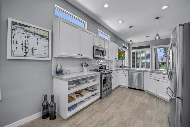 a kitchen with stainless steel appliances granite countertop a refrigerator and a sink
