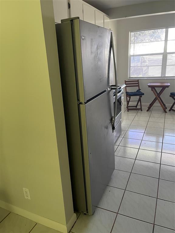 8405 Northwest 61st Street, Unit D109 Tamarac, FL 33321 - Photo 15 of 25 a close view of a refrigerator in kitchen and wooden floor