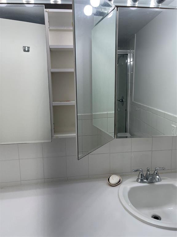 8405 Northwest 61st Street, Unit D109 Tamarac, FL 33321 - Photo 9 of 25 a bathroom with a sink and mirror